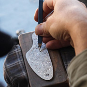 An engraver working by hand